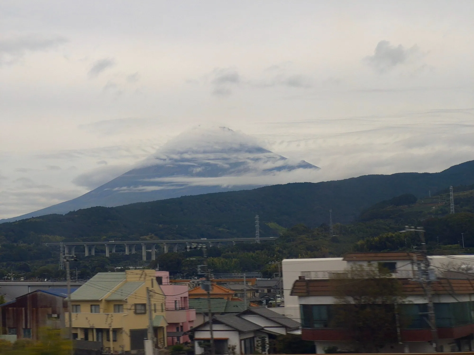 Mount Fuji wrapped in cloud, seen from the Shinkansen.